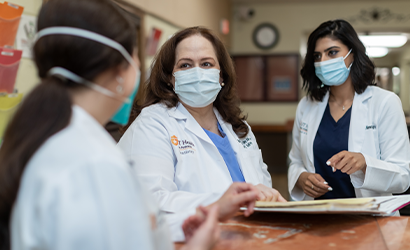 Three female doctors wearing masks in discussion