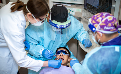 Dentists treating a child in clinic