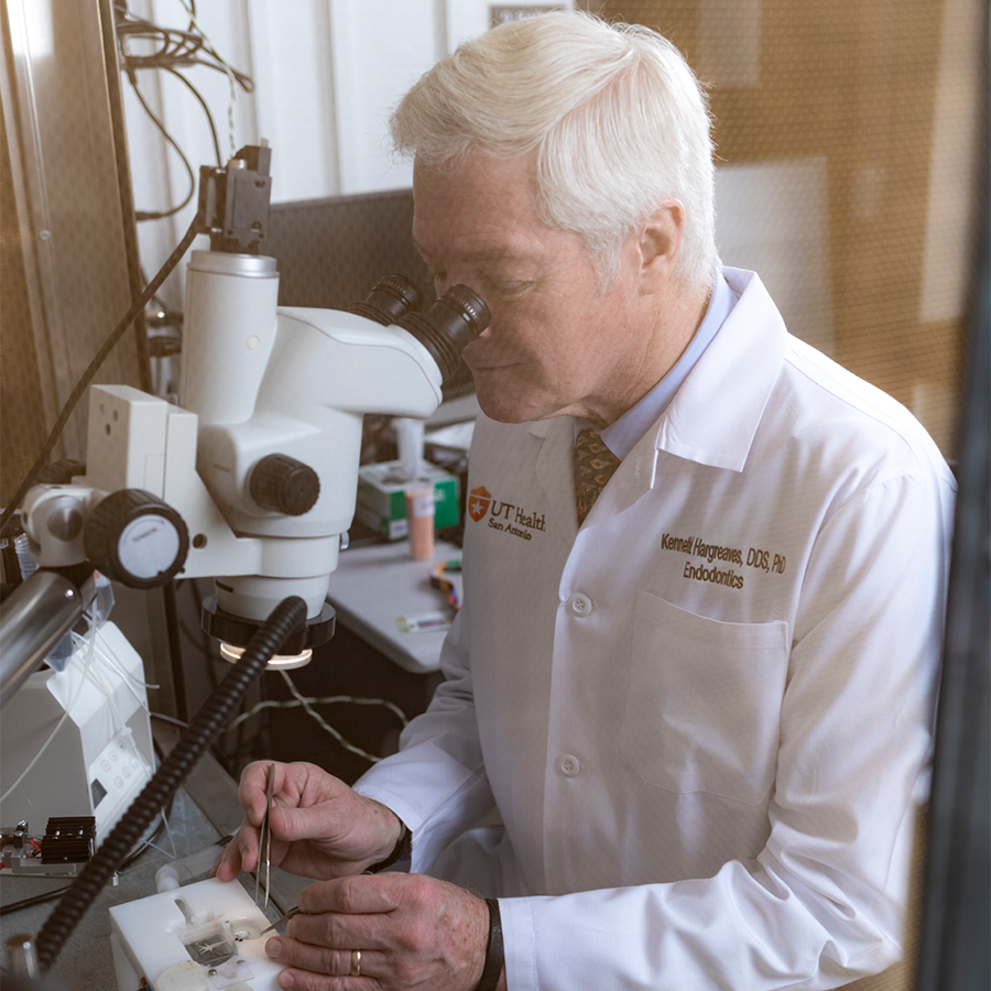 Kenneth Hargreaves, DDS, PhD looking through a microscope
