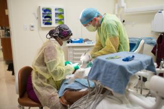 Dentist and dental assistant working on a patient.