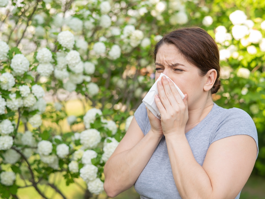 Woman sneezing because of allergies
