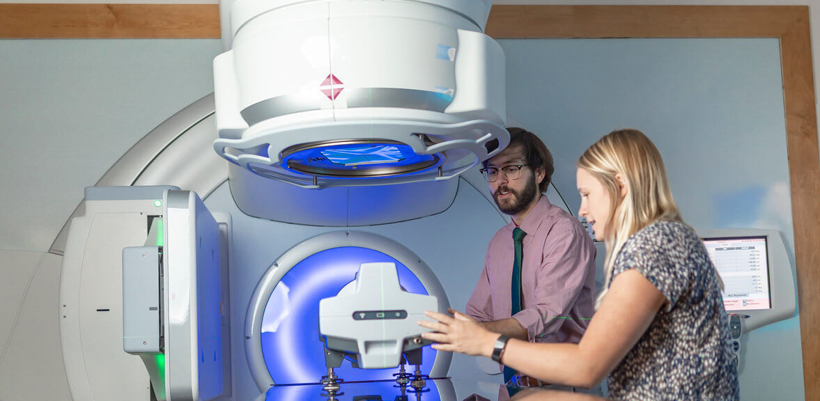 A man showing a woman how to use a medical scanning device