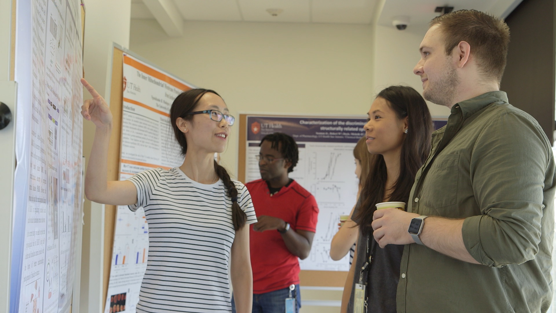 Student showing people her research poster
