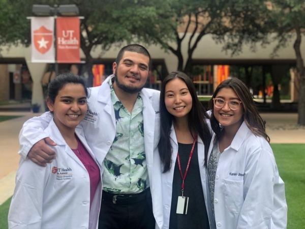 Students in white coats smiling