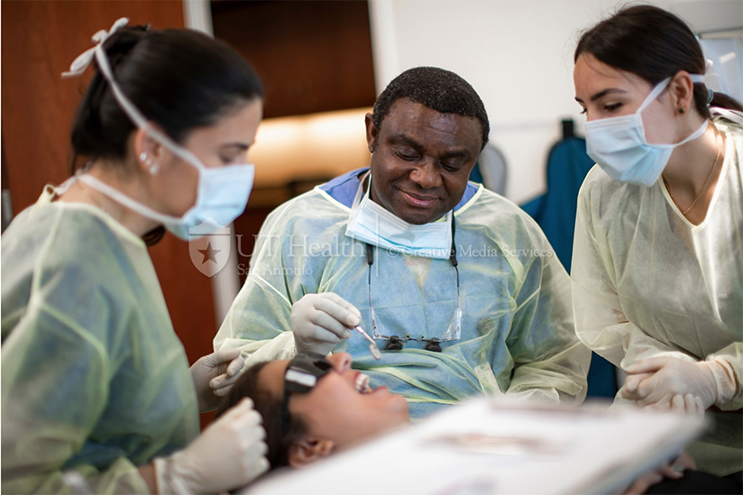 dentist and patient with two dental students assisting