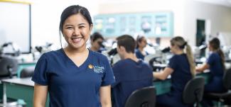 Health Professions female student smiling in blue scrubs
