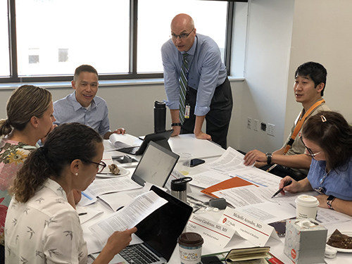 Group of faculty in discussion around conference table