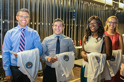 medical students posing with their white coats