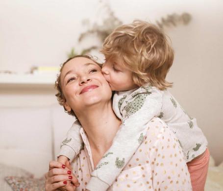 child kissing mom's cheek in a show of love