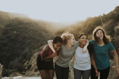 four women hiking and laughing