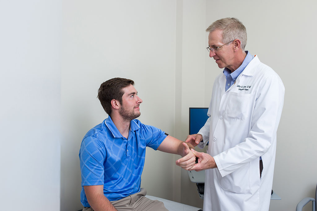 a doctor examining a man's elbow