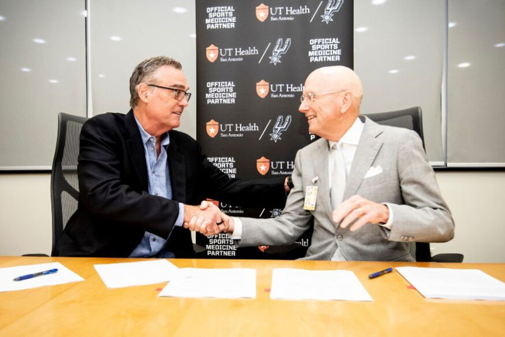 R.C. Buford, the owner of the San Antonio Spurs, shaking hands with UT Health San Antonio President William L. Henrich.