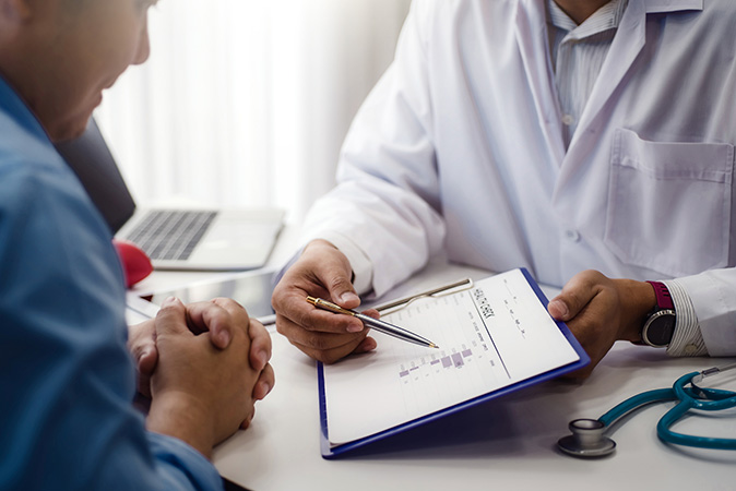 consulting doctor and patient at a desk in office