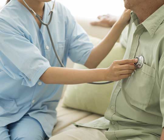 Nurse listening to patient's heart