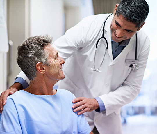 Physician talking to mature male patient