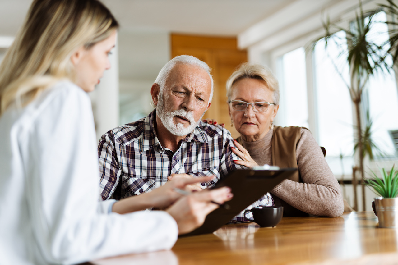 Female doctor with older patient couple