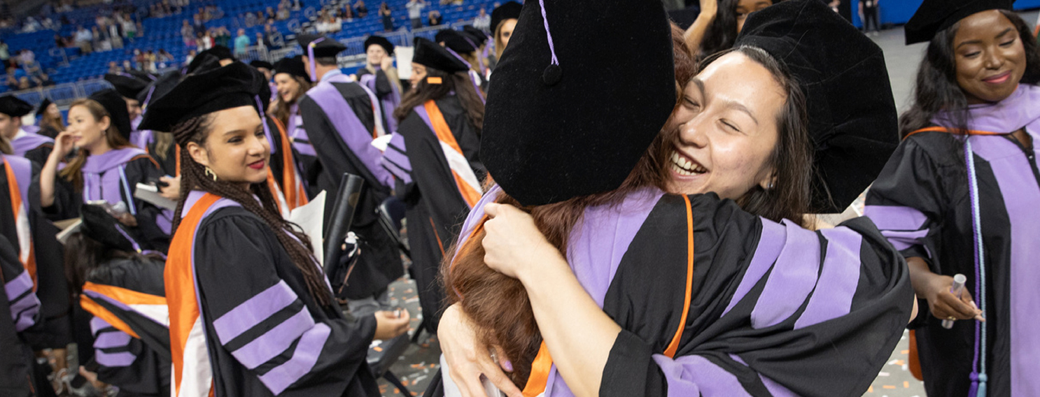 student graduating hugging each other