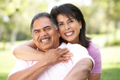 Dental patients proudly smiling to show their new crowns and dental bridges