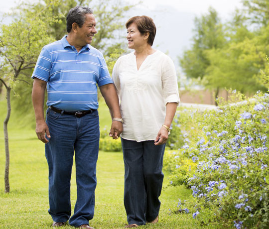 Happy couple walking through garden