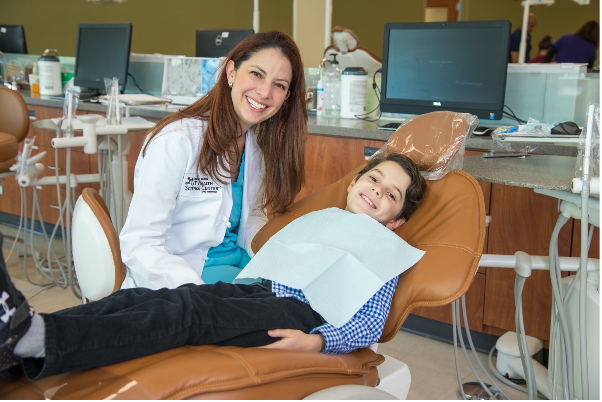 A pediatric dentist in San Antonio shows a child how to care for her teeth. 