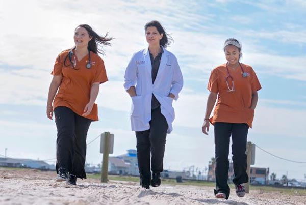 nursing students walking on sandy beach in rockport