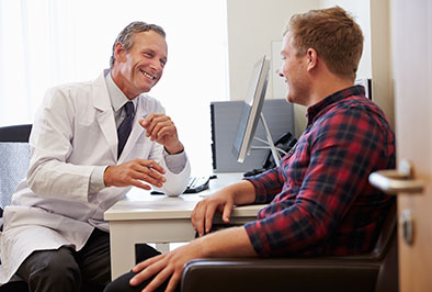 Dentist explaining to a patient how a facial prosthesis could benefit him