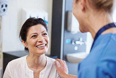 A cancer dental care surgery patient smiling at her dentist