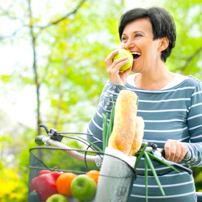 Tooth replacement patient biting in to an apple with her custom dentures