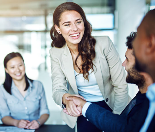 Professional woman shaking hands with coworker