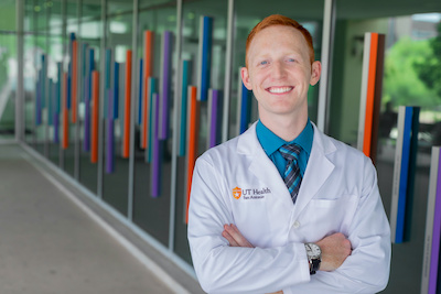 Student outside main entrance to Center for Oral Health Care and Research