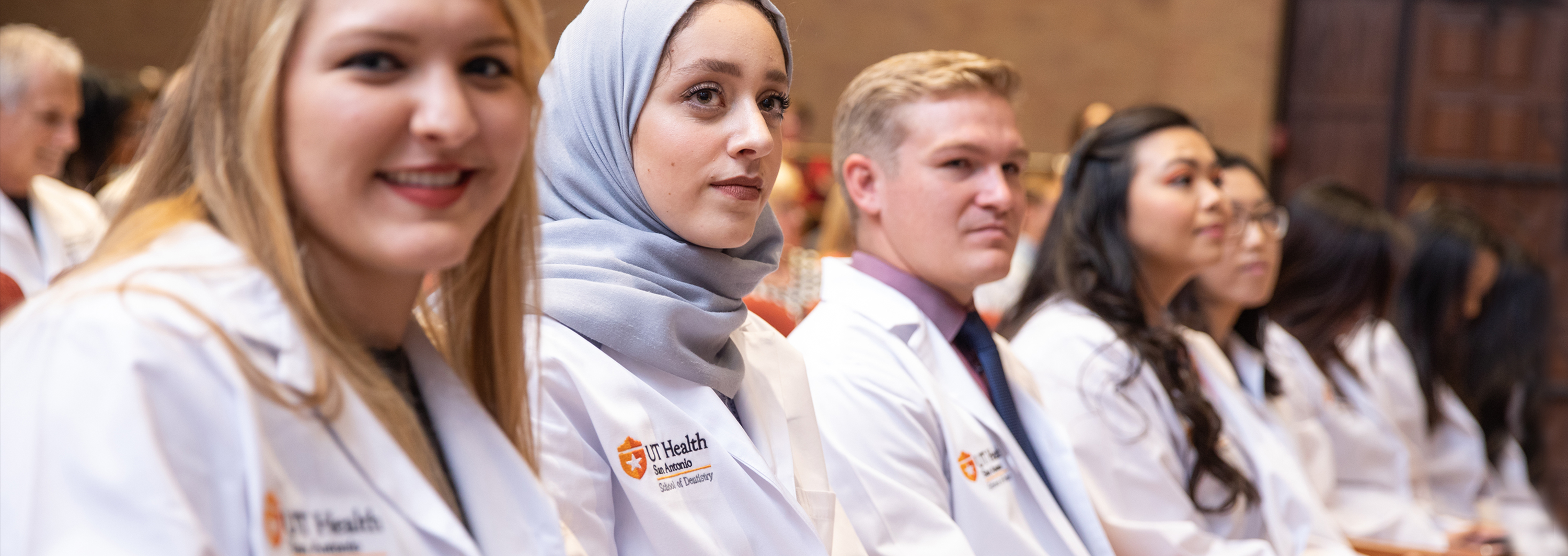 students sitting wearing white coats