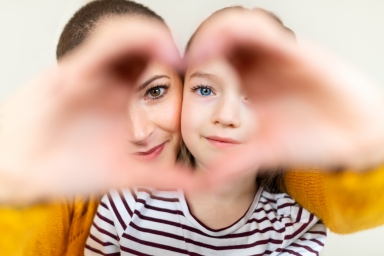 Mother daughter making a heart sign