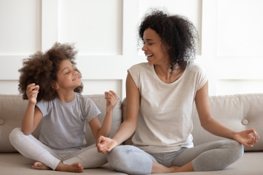 adult woman and child in the lotus pose
