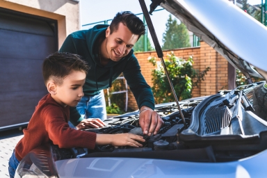 Father and son inspecting a car