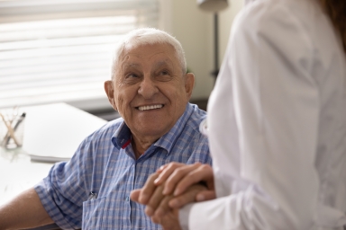 older man holding doctor's hand