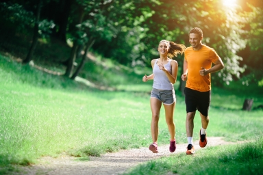 male and female couple running down a path