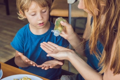 Mom with child using hand sanitizer