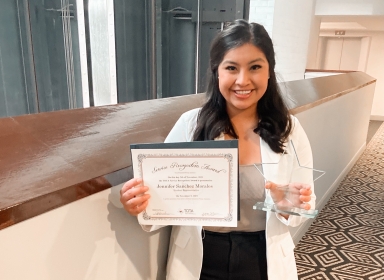 Occupational therapy student Jennifer Sanchez holding her student leadership award from TOTA