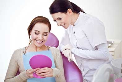 Patient admiring her teeth after a deep cleaning to prevent gum disease and periodontal disease