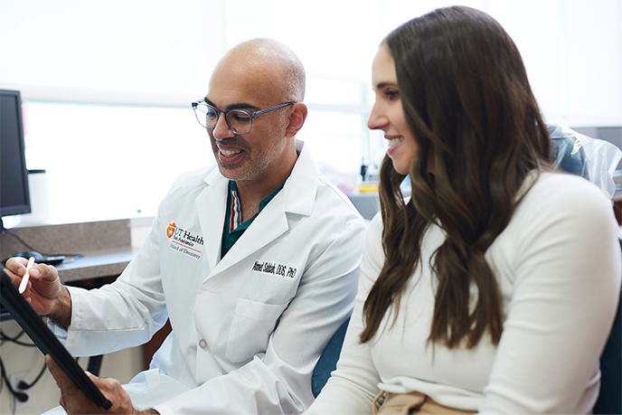 Dentist and patient looking at tablet together