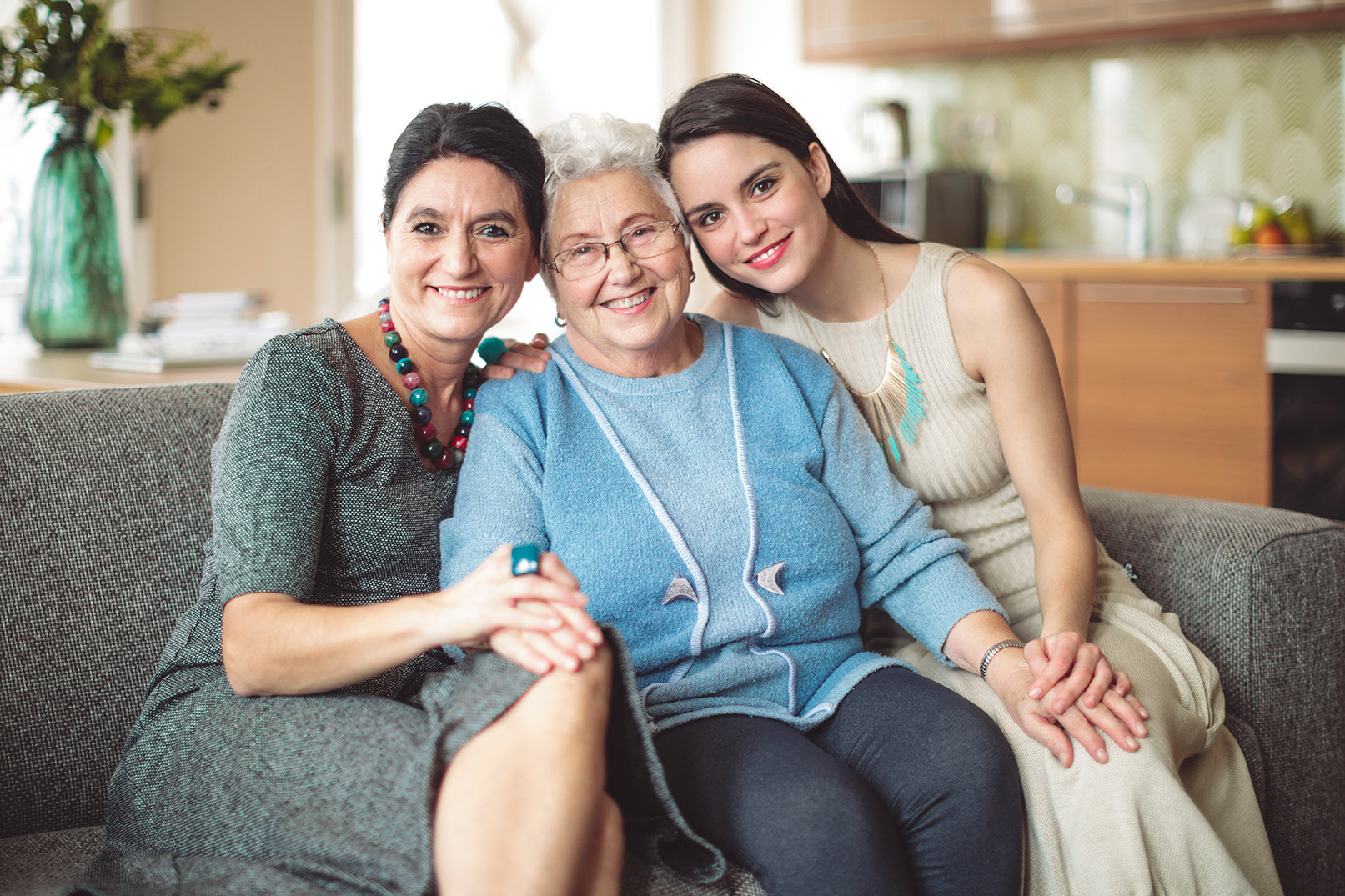 Three women sitting on a couch smiling