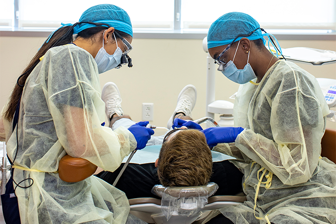 Student dentist and assistant working on patient