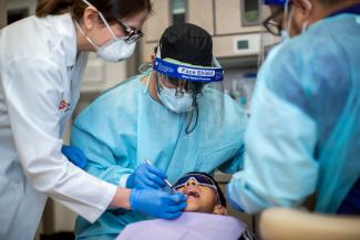 Dentists working on a child's teeth